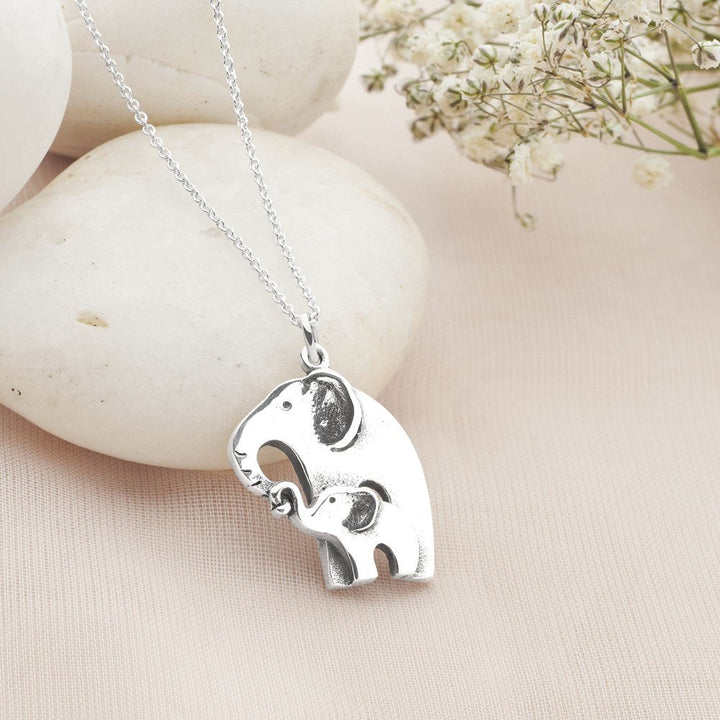 Stylised close up of mother & baby embrace necklace
