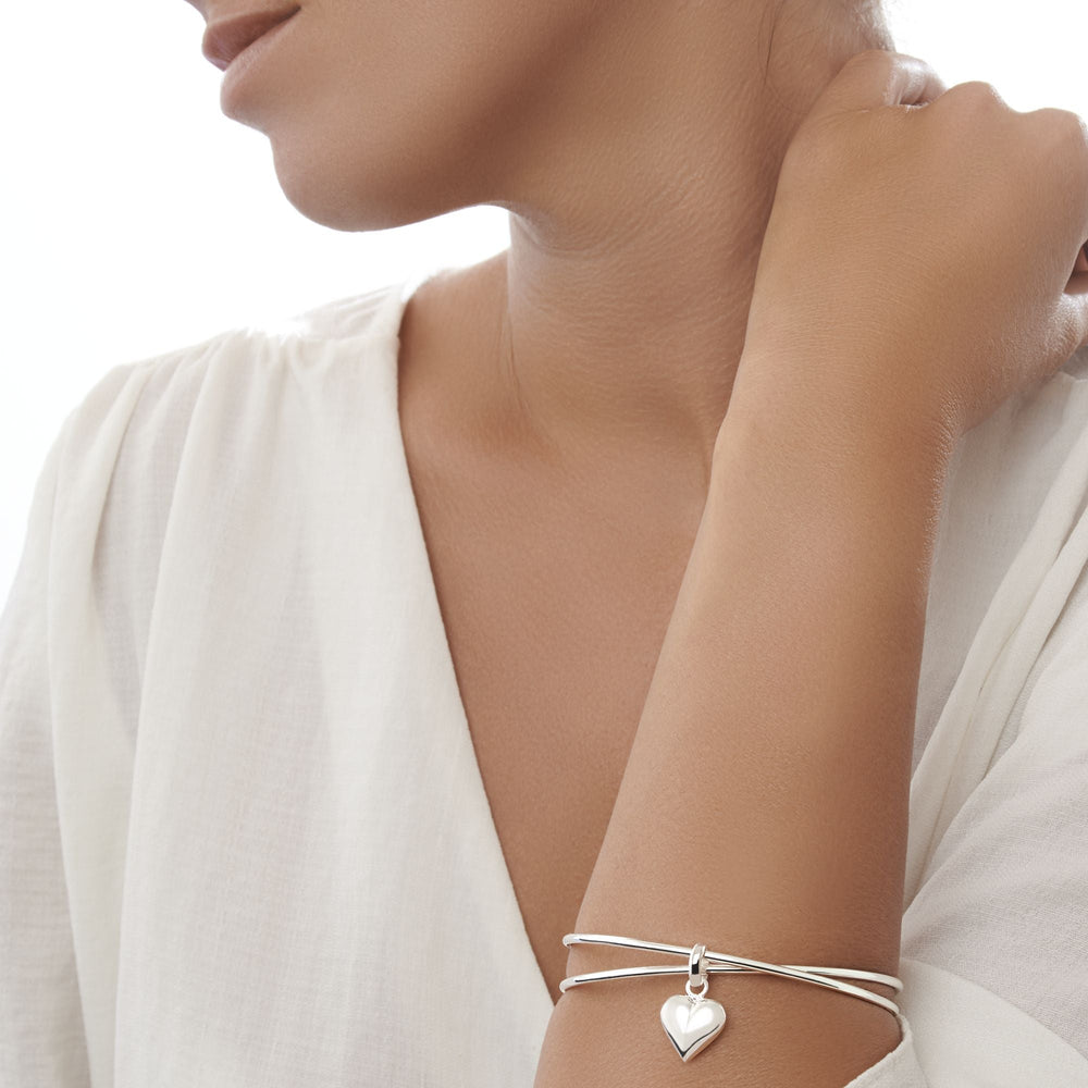 925 sterling silver double band bangle with heart charm. On female model