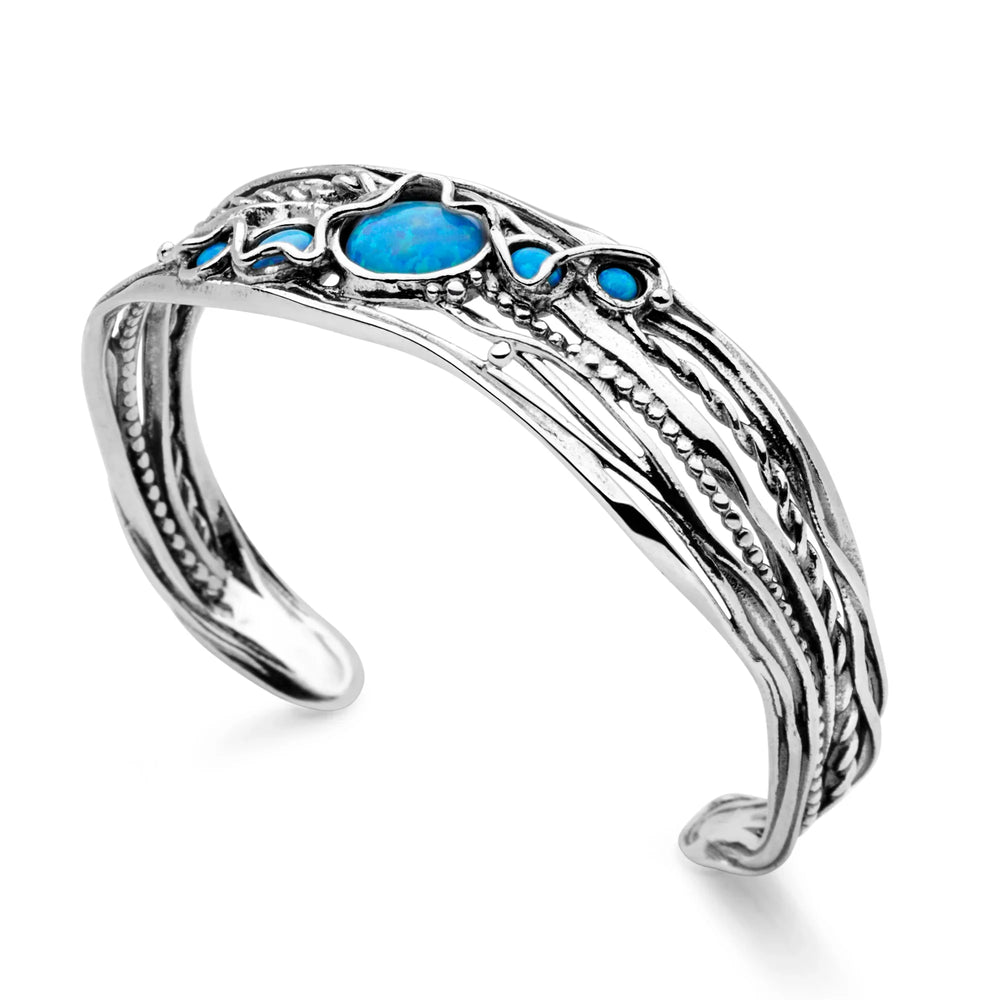 A sterling silver open cuff bangle featuring synthetic blue opal stones, set in a delicate openwork design of intertwined silver threads.