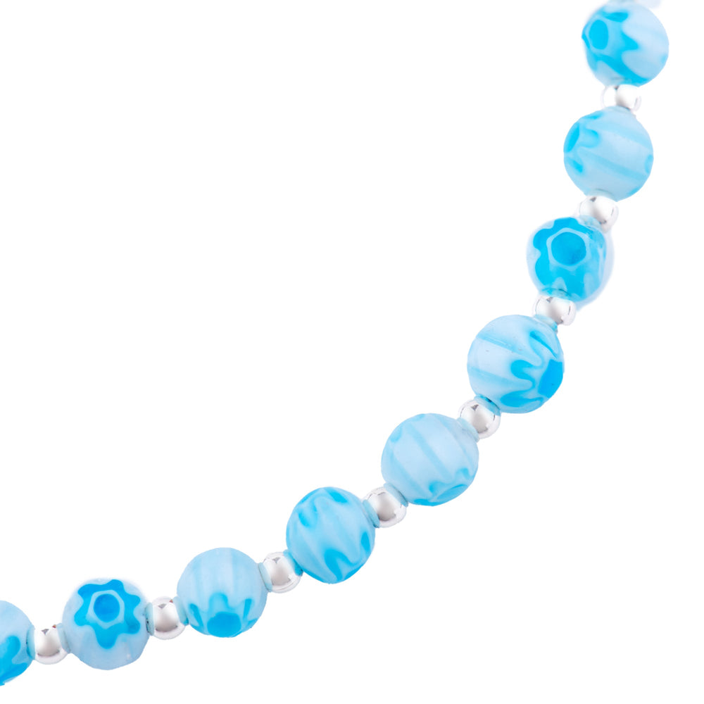 A bright blue Venetian style glass bead bracelet with a sterling silver clasp and chain, displayed against a white background close up. 