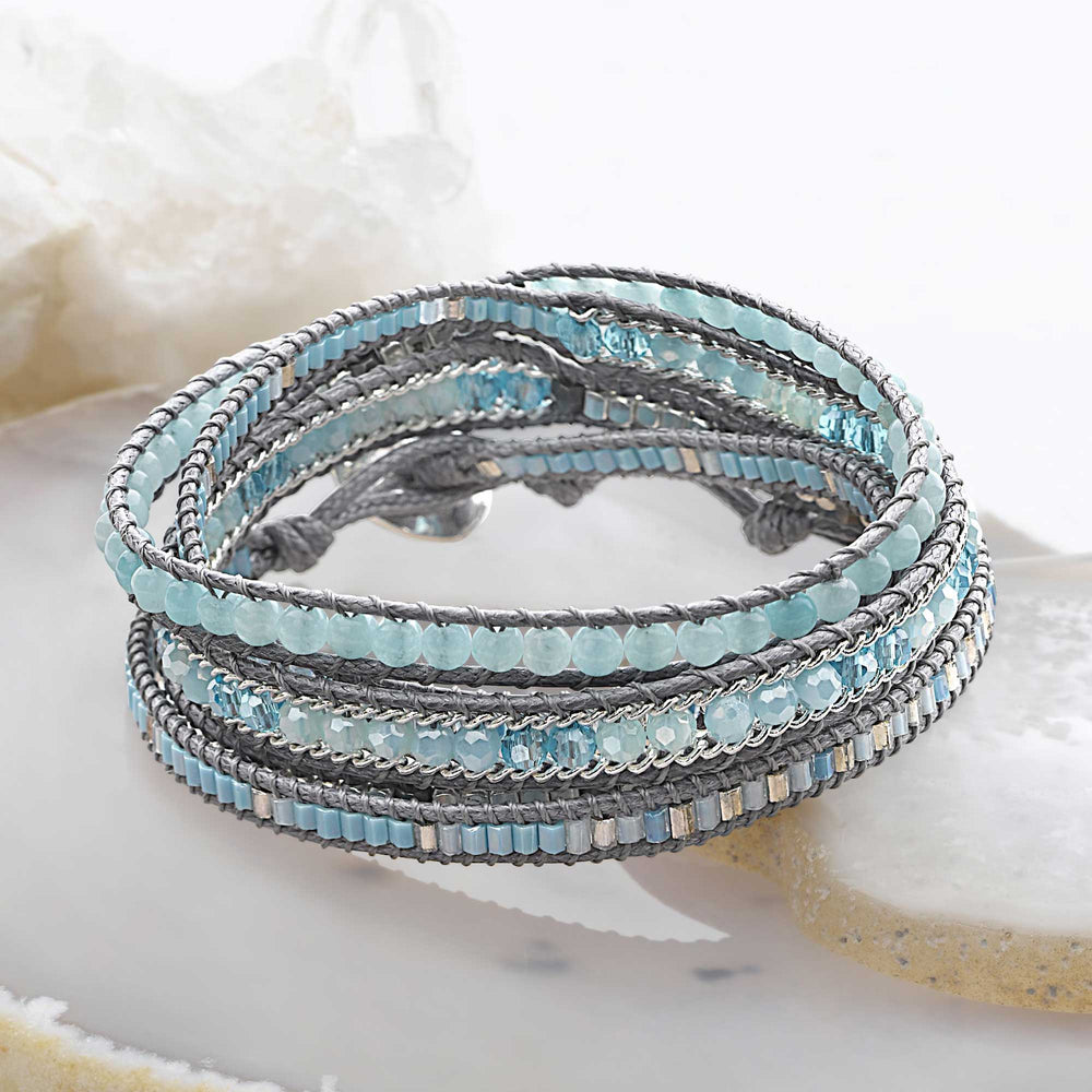 A wrap bracelet with semi precious blue beads and silver accents, fastened with a shiny 925 sterling silver disc button & secure loop.