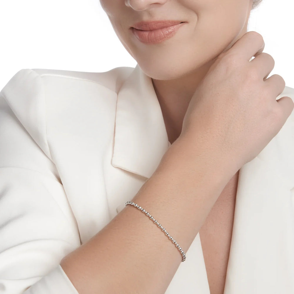 A one-size silver bracelet made of perfectly formed beads, with a high polish finish on woman model