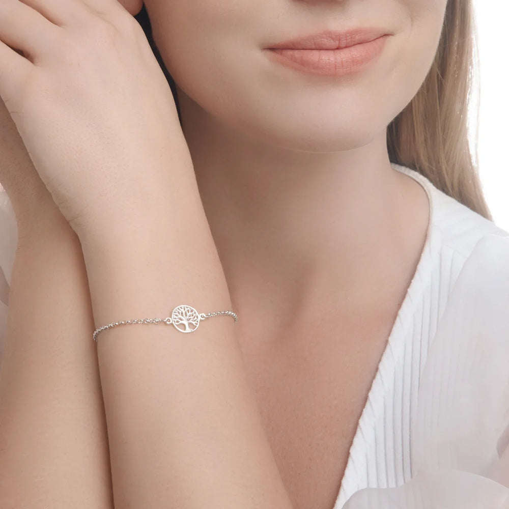 A sterling silver bracelet featuring a tree of life charm, adjustable in length, displayed against a woman model