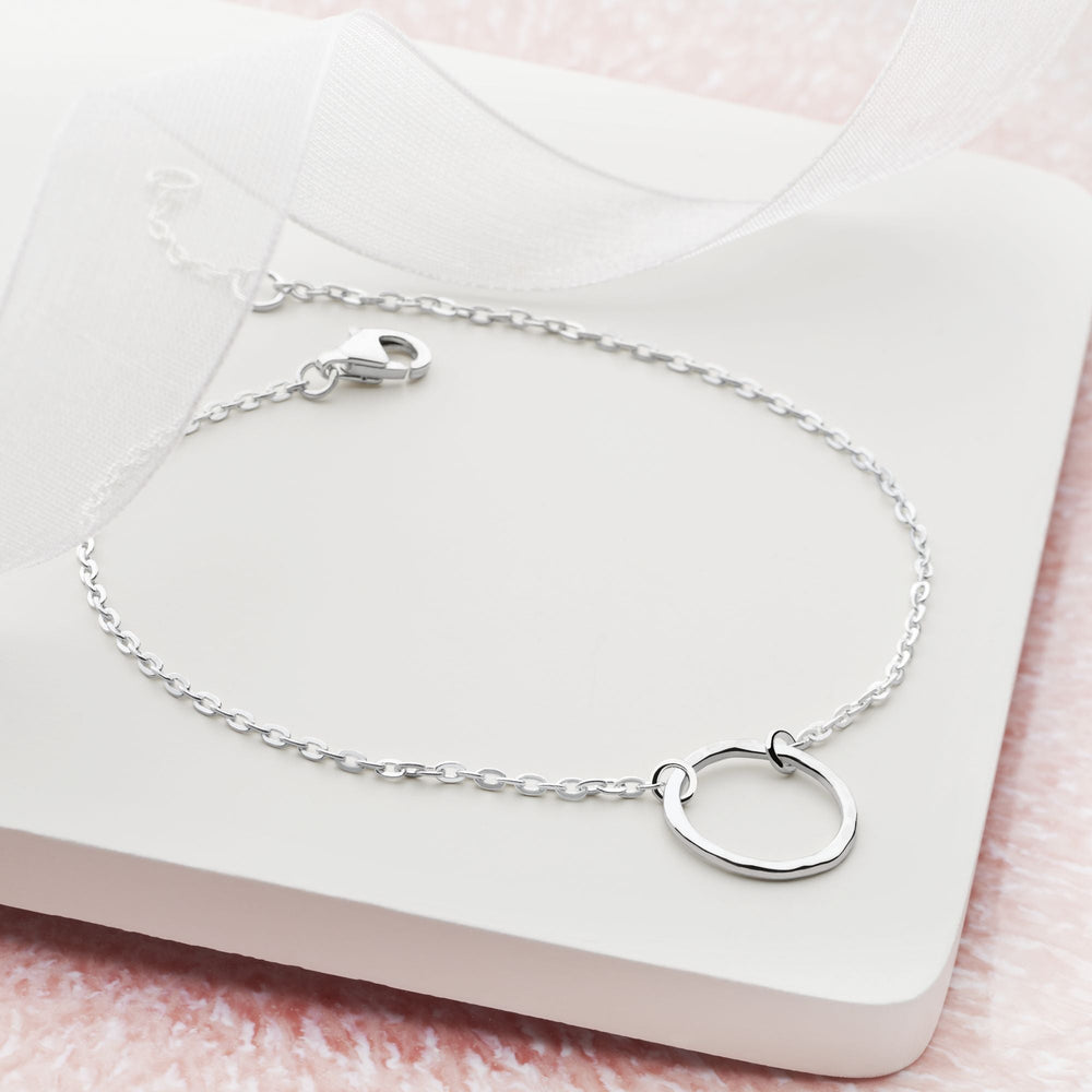 Silver bracelet with a round clasp on a white background