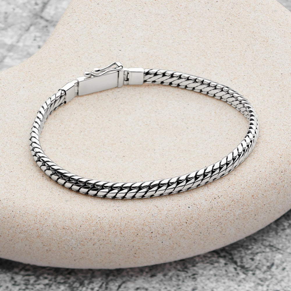 Silver braided bracelet on a stone surface