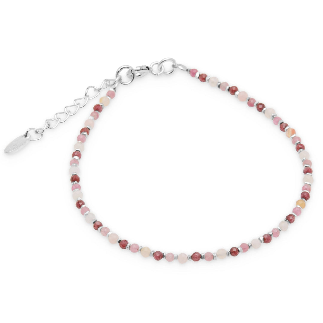 A bracelet with faceted garnet, pink opal, and tourmaline beads along with silver beads, displayed against a white background.