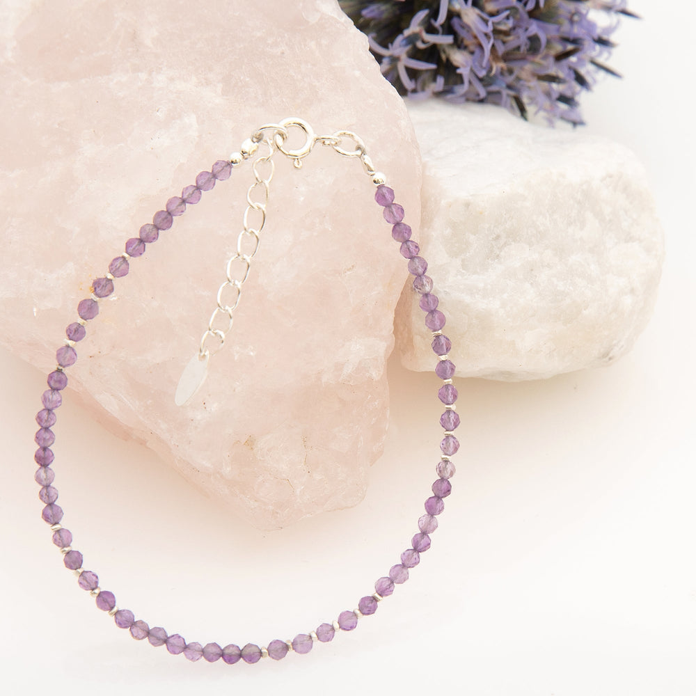 A bracelet with faceted amethyst beads and silver beads, finished with a silver clasp.
