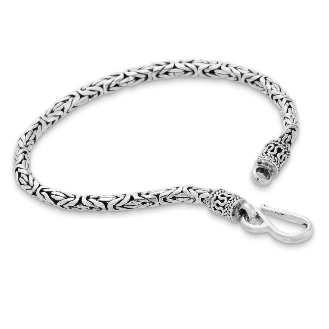 A silver bracelet with a sinuous, twisting design and a high polish finish, featuring a clasp.