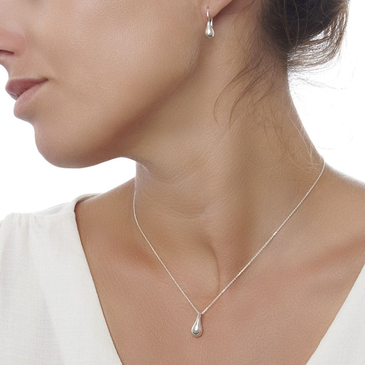 Model shot of a silver drop-shaped pendant necklace with a high polish finish featuring sweetest silver drop earrings