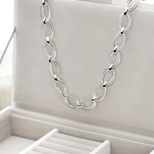 A silver necklace with a T-bar clasp and polished finish, featuring linked ovals. 925 sterling silver. 