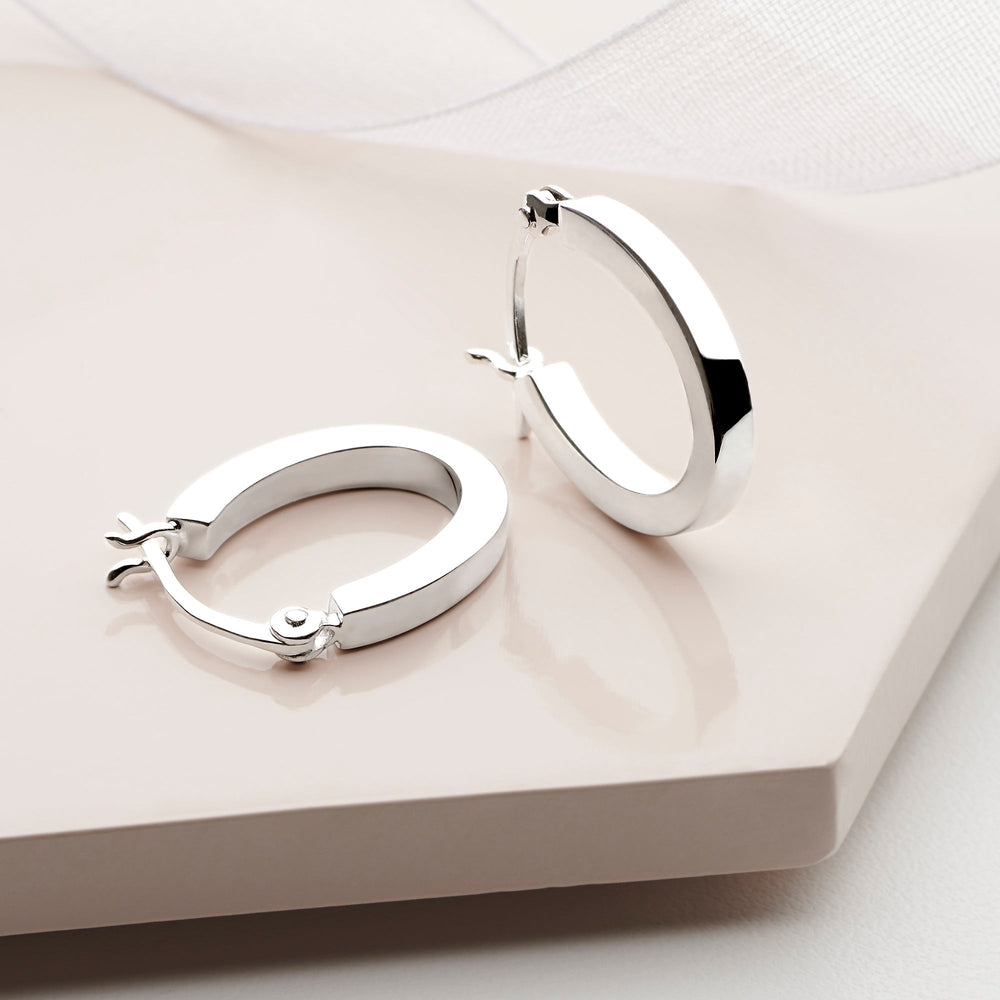 A pair of silver hoop earrings with a high polish finish and secure clip-clasp fixing.