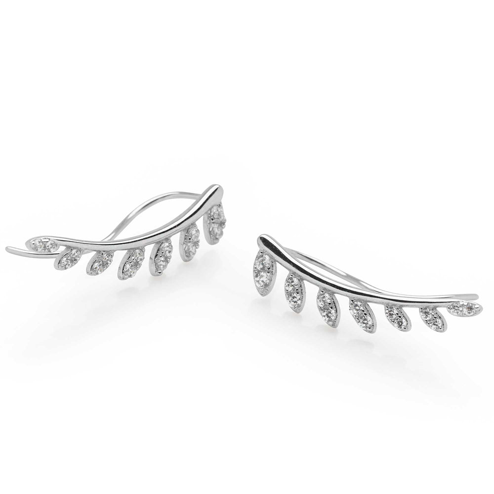 A person wearing a leaf ear climber earring with sparkling cubic zirconia stones attached to their ear.