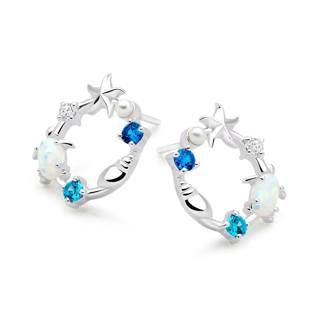 A pair of silver earrings featuring a sea-themed design with opals, pearls, and sparkling cubic zirconia stones arranged in the shape of an ocean reef.