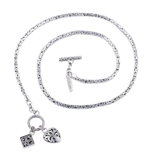 Balinese silver necklace with heart and square charm on a white background