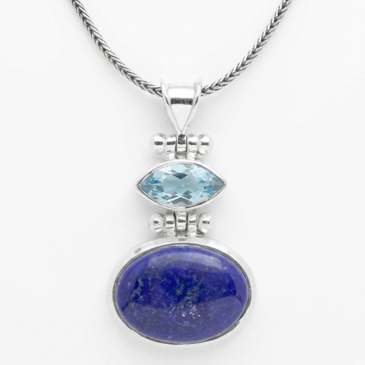 Silver pendant with blue gemstone on a white background
