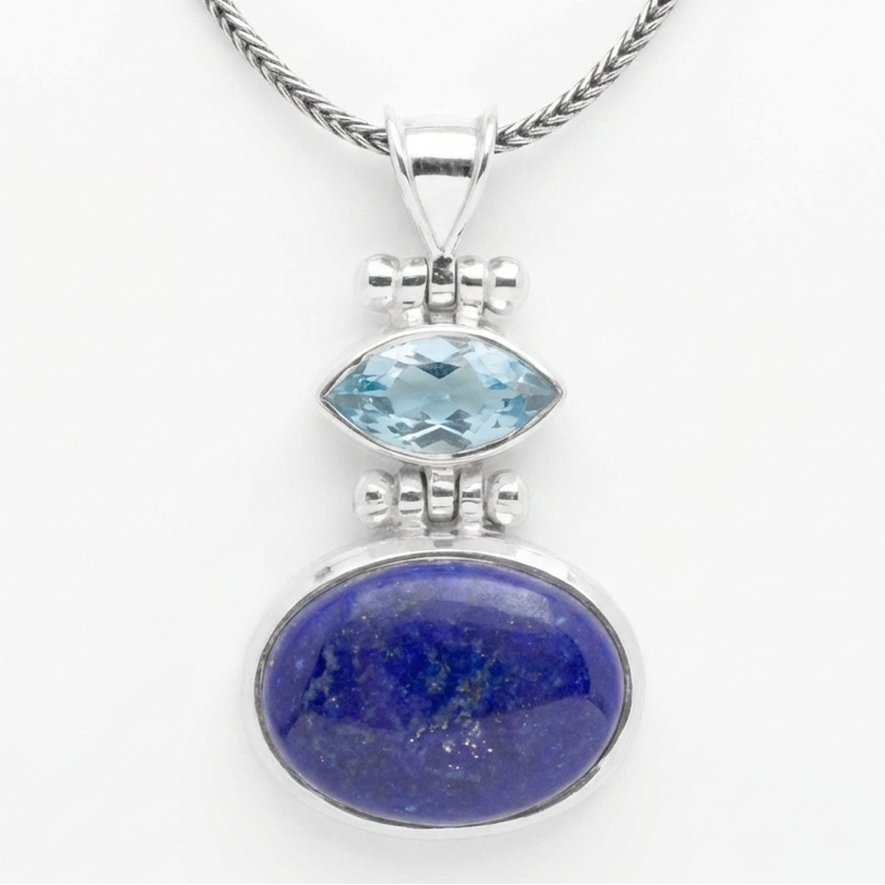 Silver pendant with blue gemstone on a white background