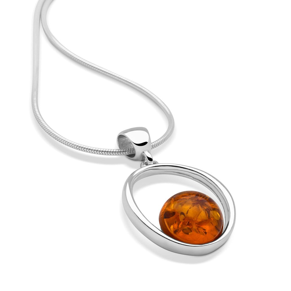 A silver pendant with an amber dome in a round frame attached to a snake chain.