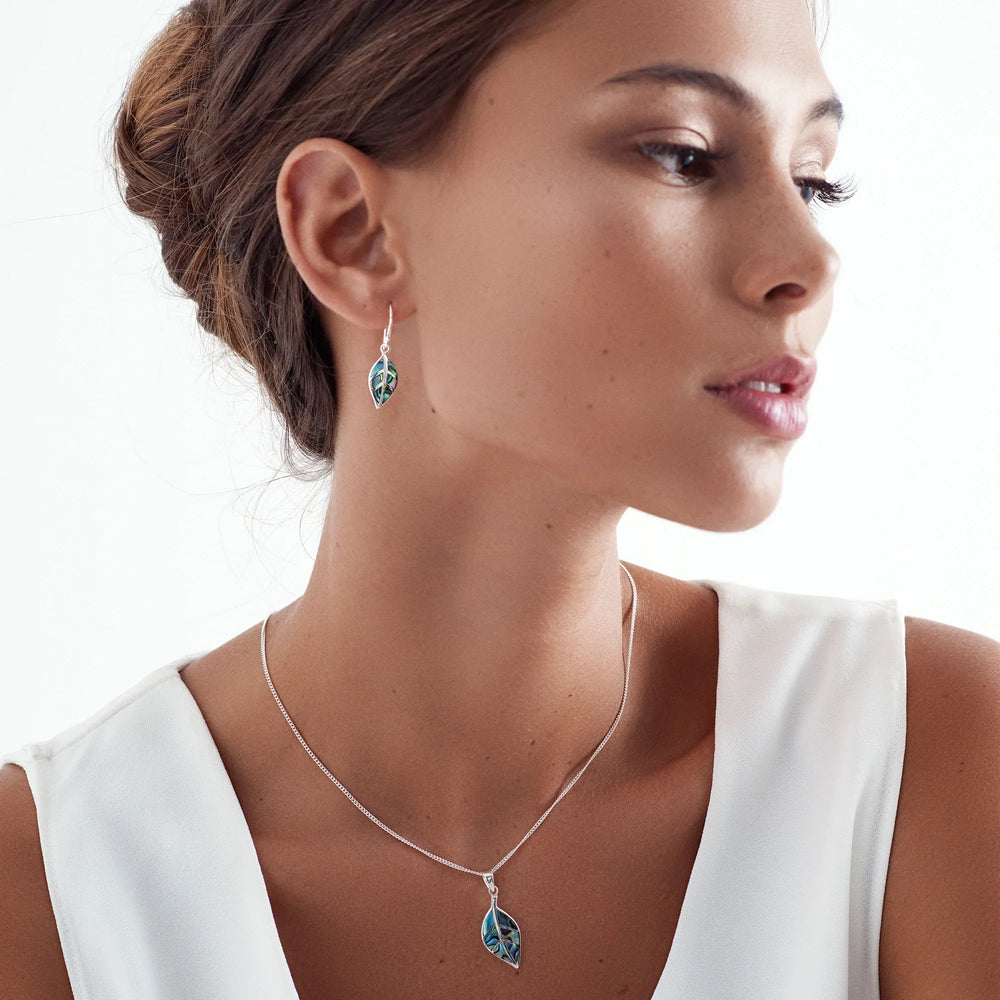 Woman wearing a silver necklace and earrings on a white background