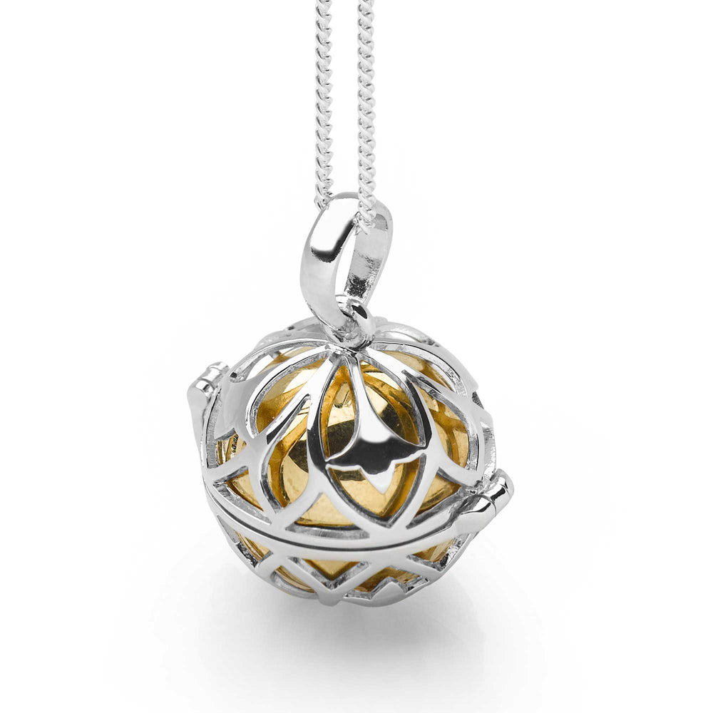 A silver pomander pendant with a golden globe-like chiming orb inside, displayed against a white background.