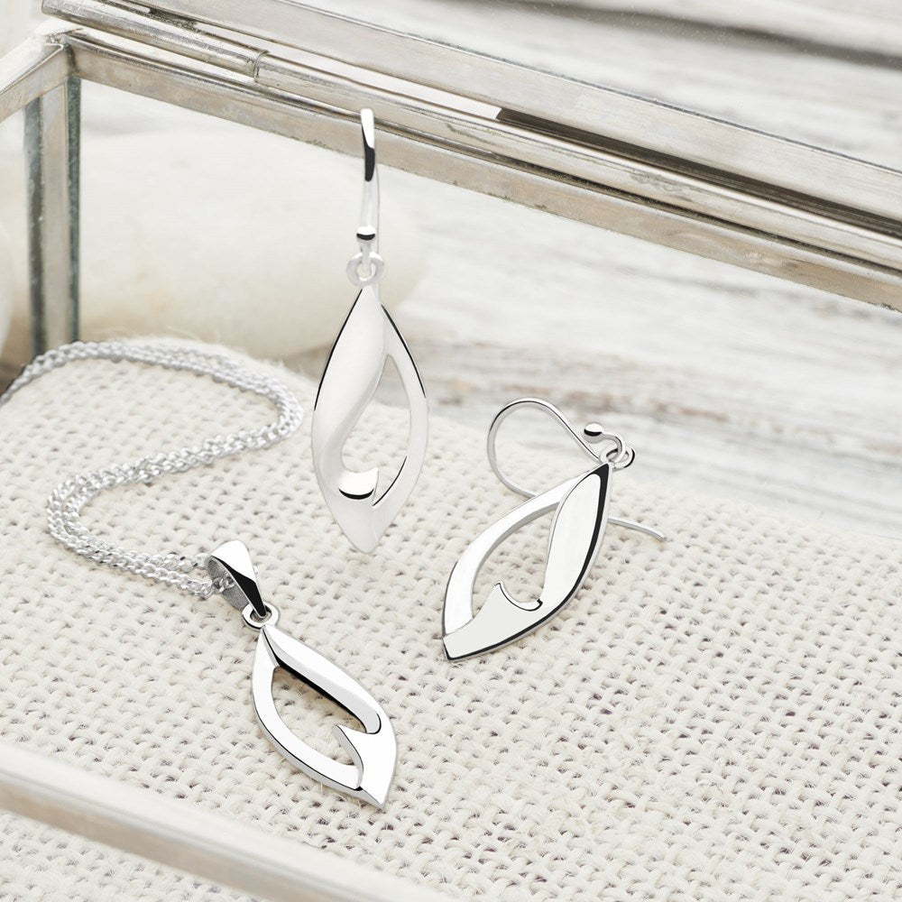 A silver pendant and earring in the shape of a gum tree leaf with a cut-out silver heart detail, attached to a curb chain.