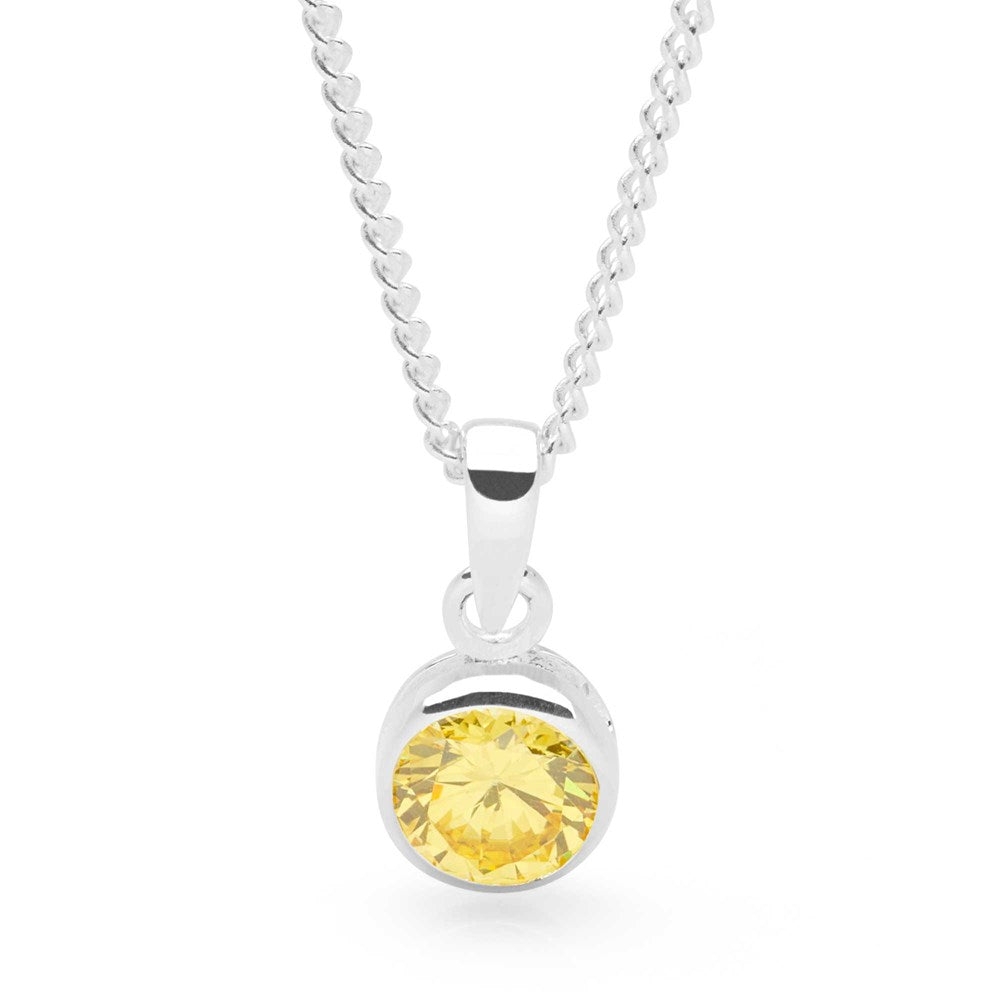 A sterling silver pendant with a yellow cubic zirconia set in a round, bezel-style setting, attached to a silver curb chain.