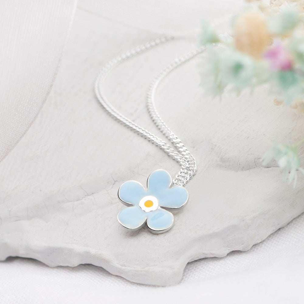A blue petal-shaped pendant with a white and yellow center, attached to a silver curb chain.