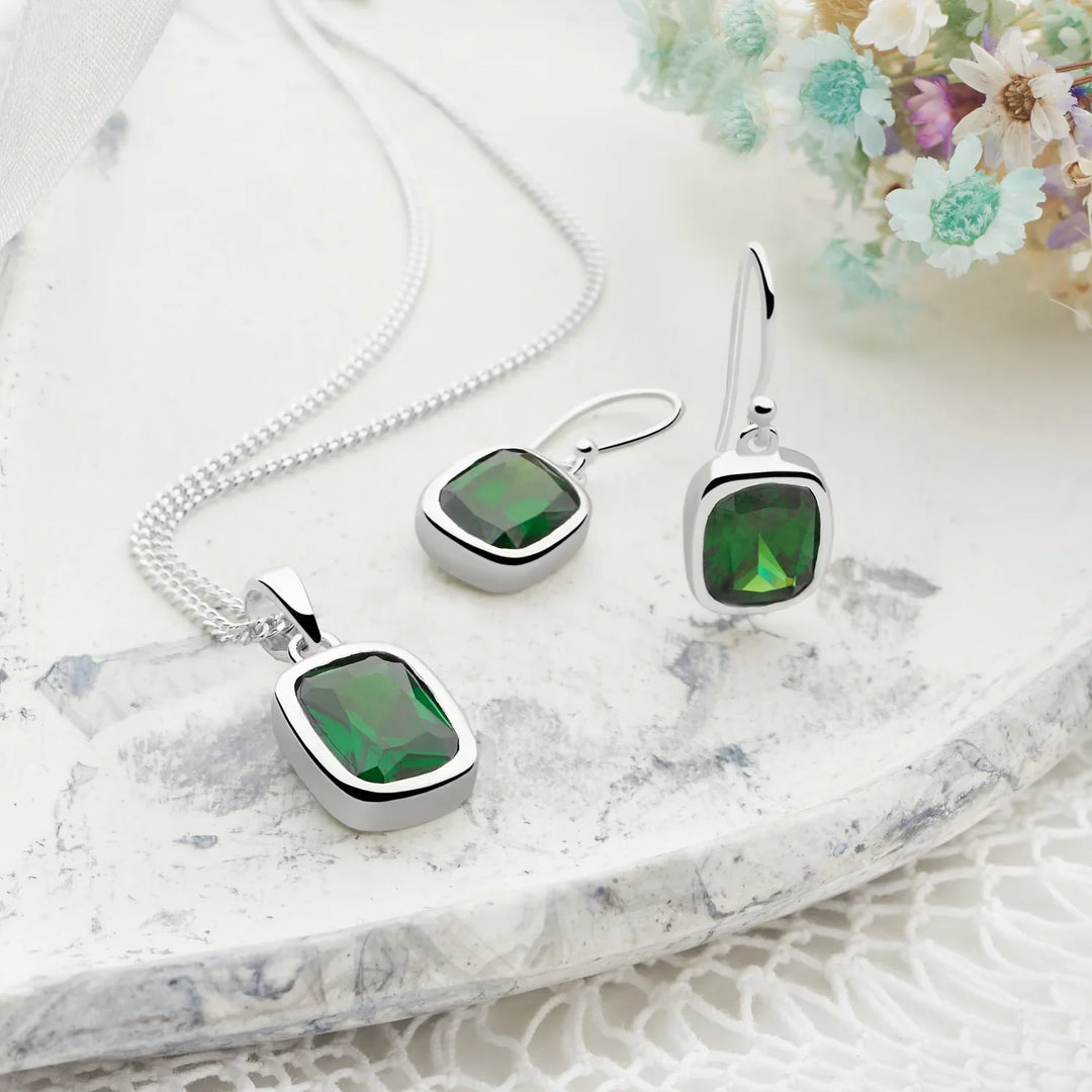 A sterling silver pendant and earrings with a large emerald green cubic zirconia stone set in a square frame, attached to a 40cm curb chain.