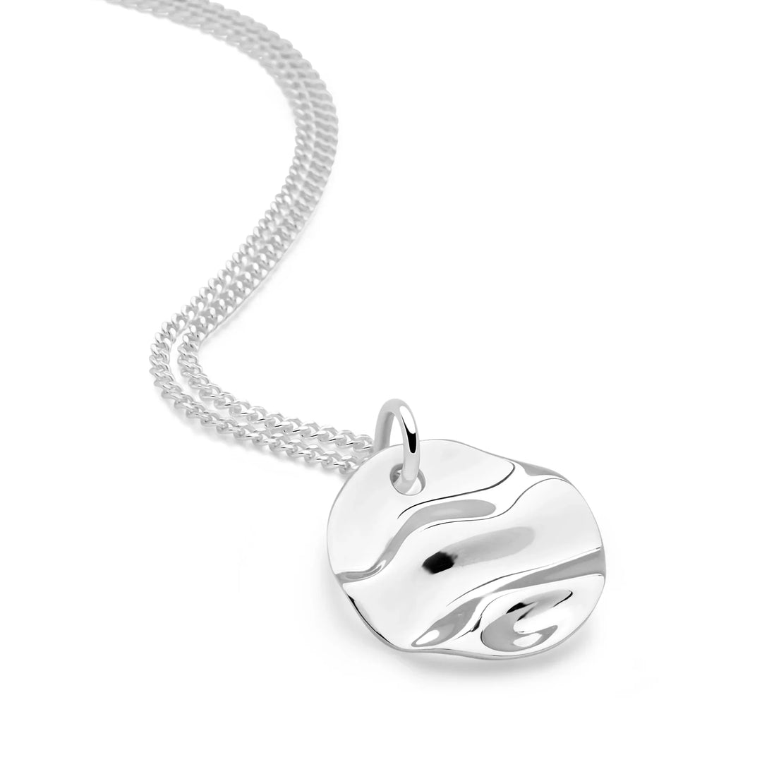 Silver necklace with a round pendant on a white background