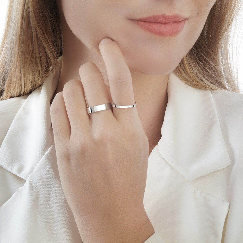 A flat silver band ring with a smooth finish, displaying the ring's width of 5mm sterling silver on female model. 