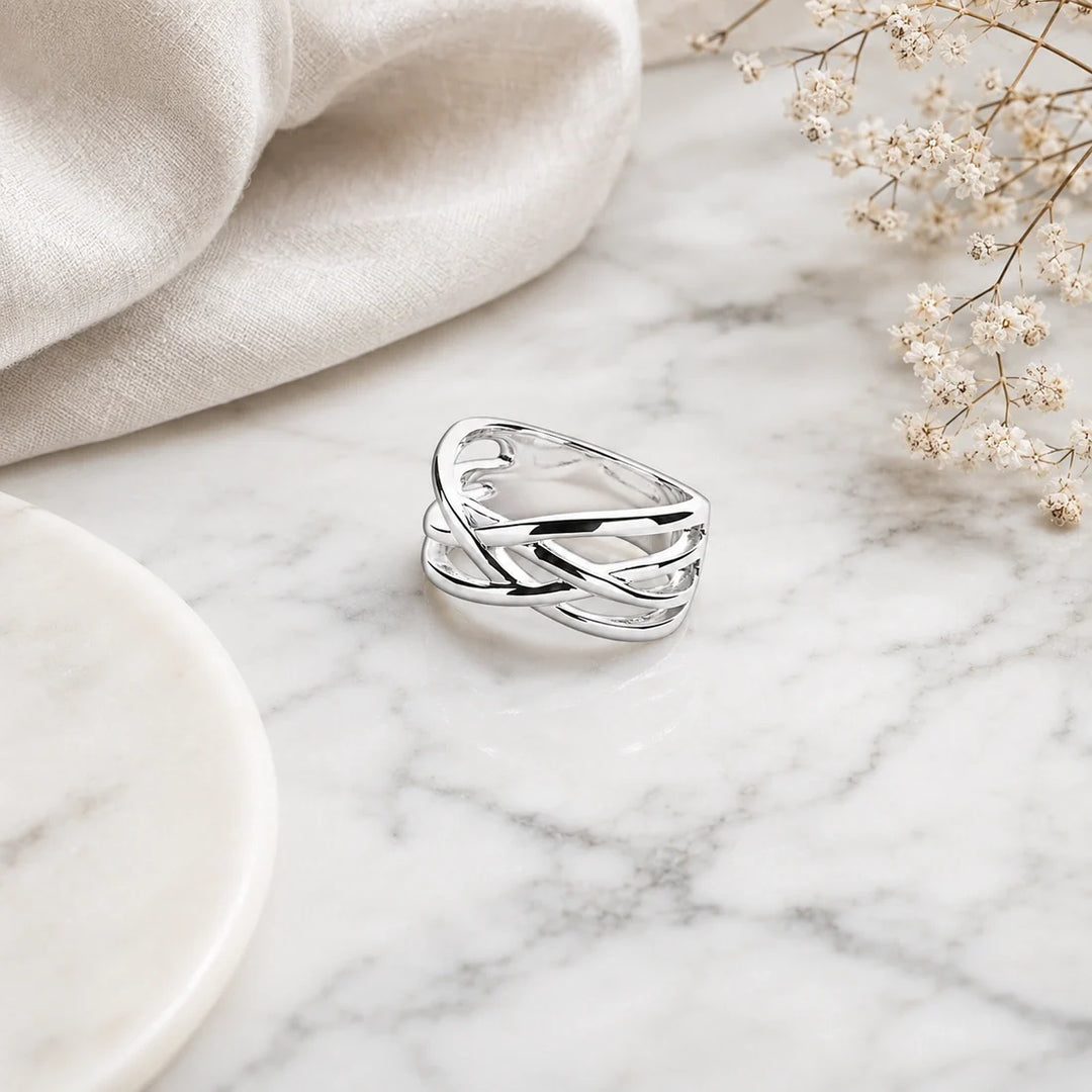A wide sterling silver crossover ring with smooth, intertwined multi-strand lattice bands.