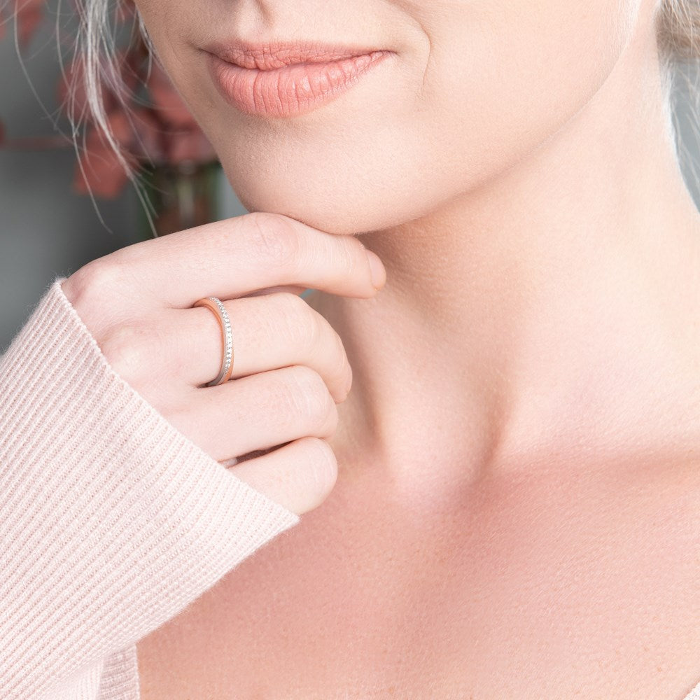 A chic silver and rose gold plated ring with sparkling cubic zirconia stones on the bridge on model. 