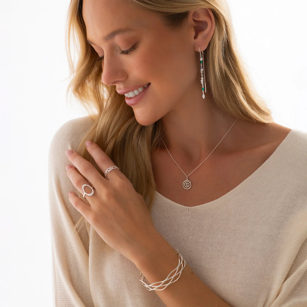 A high polish hammered finish sterling silver ring with an oval shape design on woman model. 