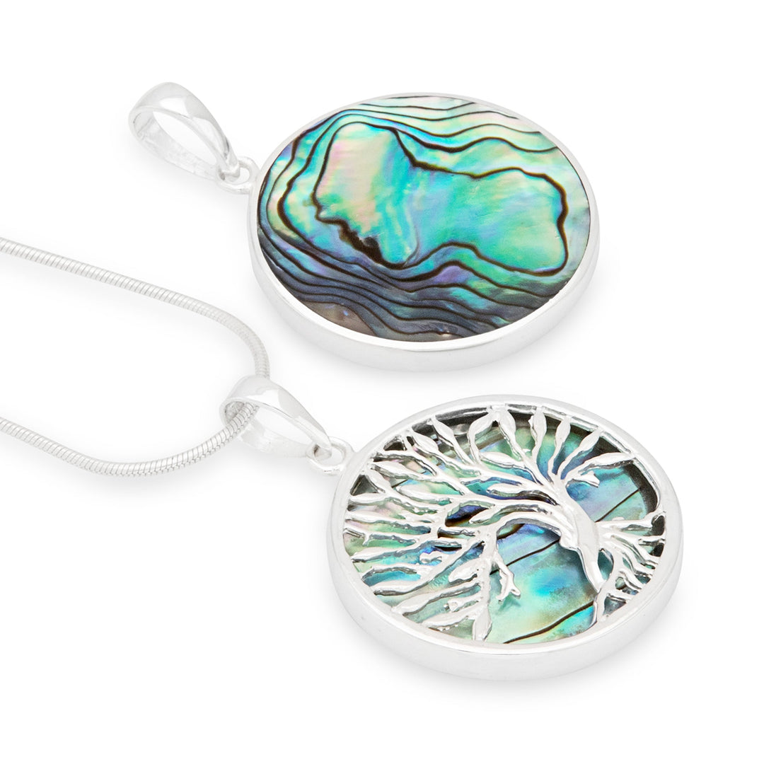 Two circular pendants, one with a Tree of Life design and the other featuring a multicolored abalone shell, both set in silver settings, accompanied by a silver snake chain.