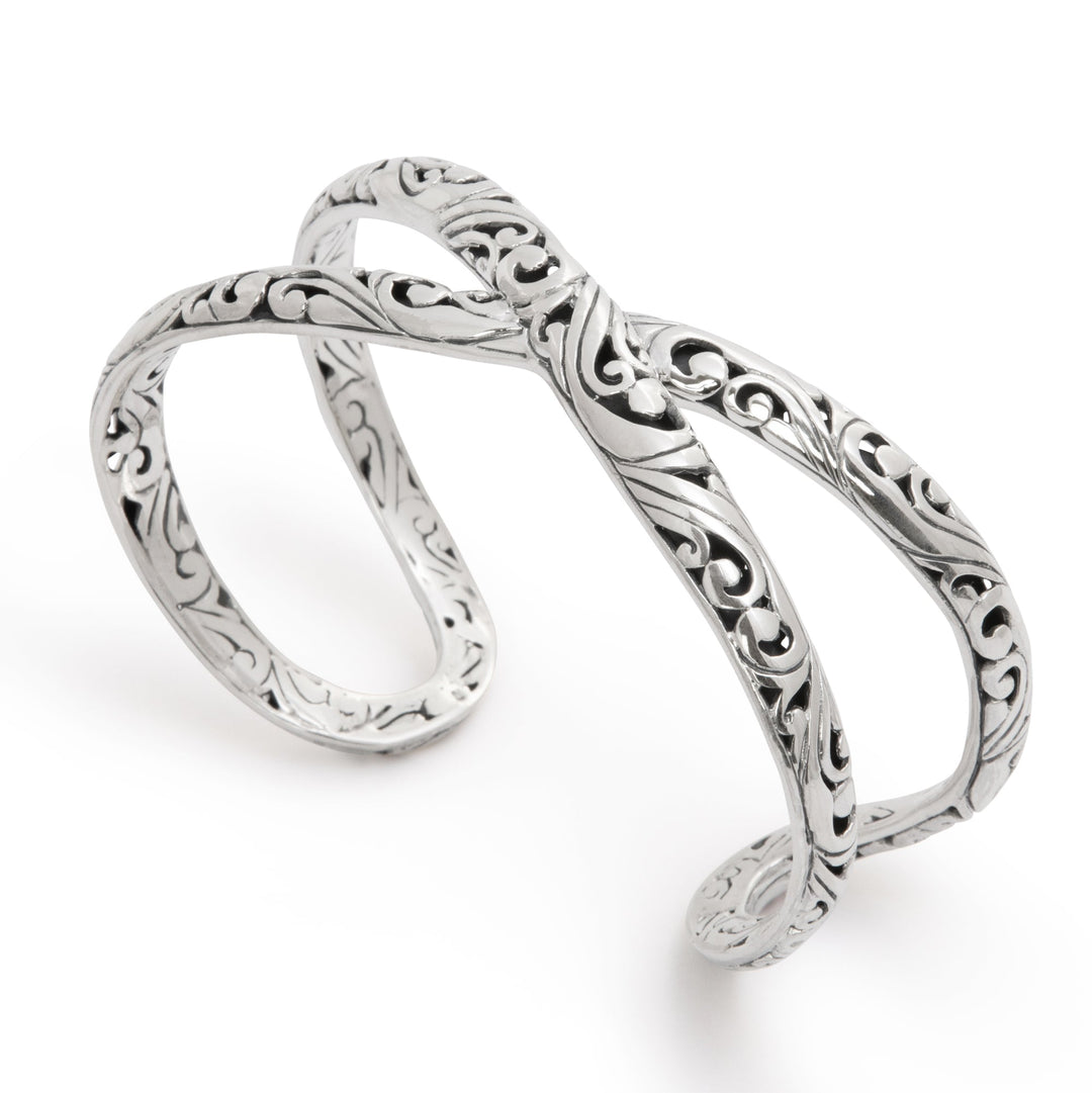 Silver infinity ring with intricate designs on a white background