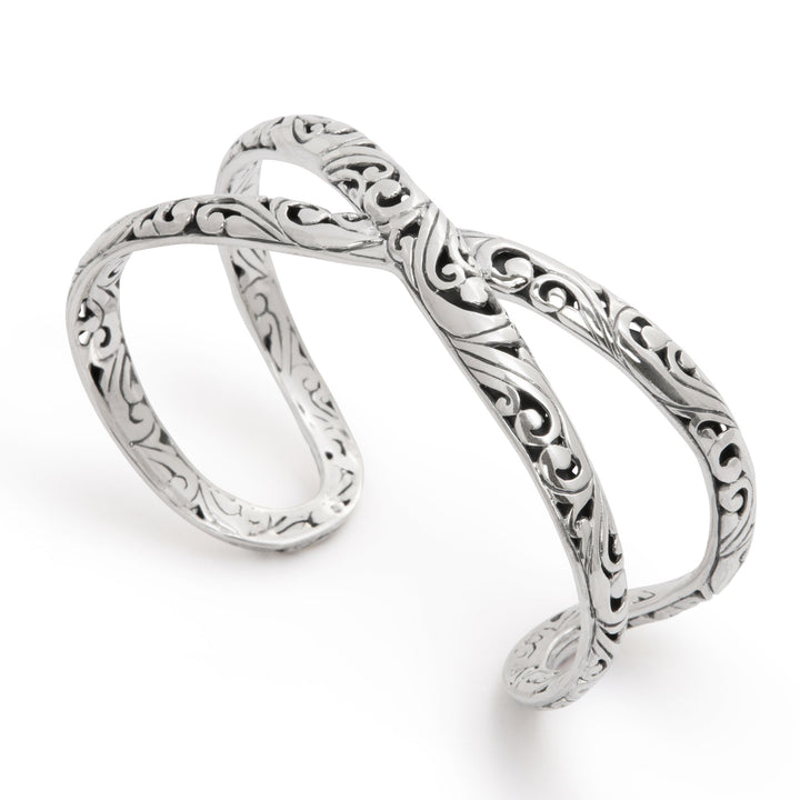 Silver infinity ring with intricate designs on a white background
